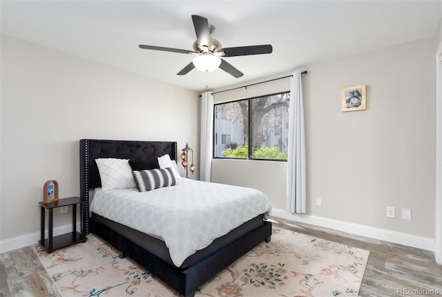 bedroom featuring baseboards, ceiling fan, and wood finished floors