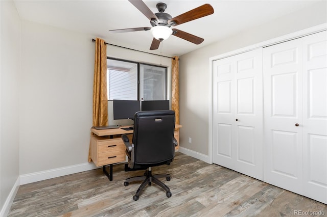 office space featuring ceiling fan, light wood-style flooring, and baseboards