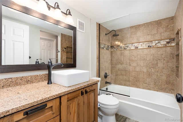 bathroom featuring toilet, shower / washtub combination, wood finished floors, vanity, and visible vents