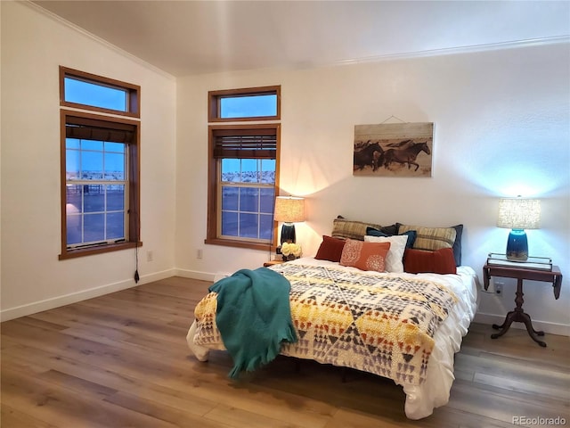 bedroom featuring crown molding, dark hardwood / wood-style flooring, and vaulted ceiling