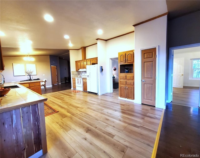 kitchen featuring tile countertops, white appliances, sink, light hardwood / wood-style flooring, and tasteful backsplash