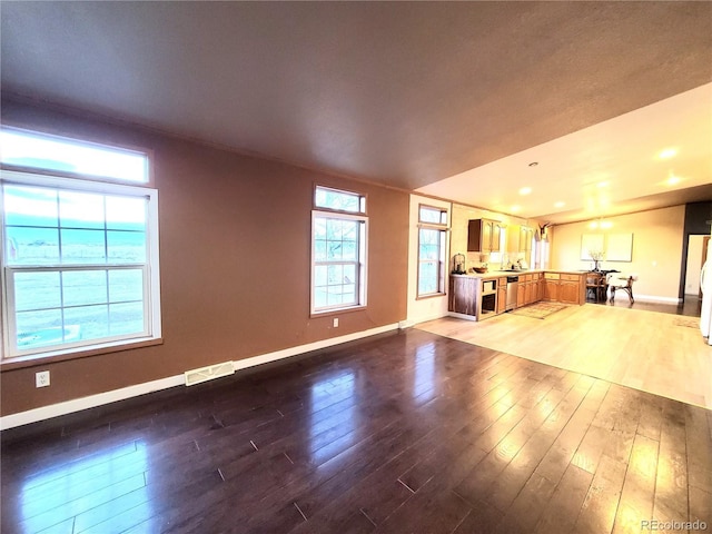 unfurnished living room featuring hardwood / wood-style floors and plenty of natural light