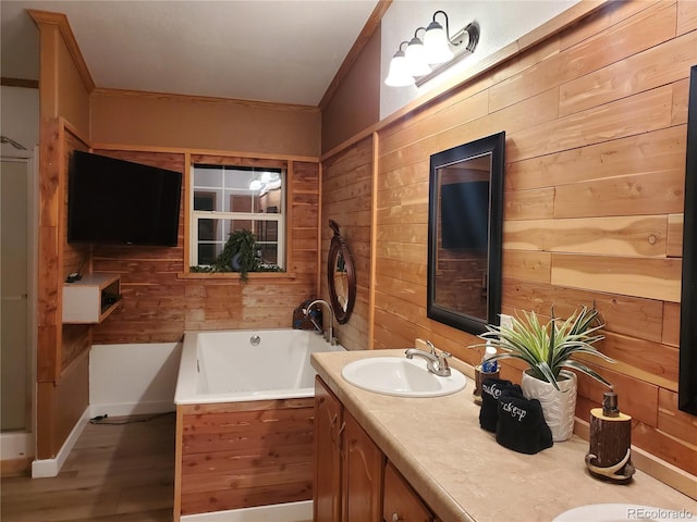 bathroom featuring a tub to relax in, ornamental molding, vanity, wooden walls, and hardwood / wood-style flooring