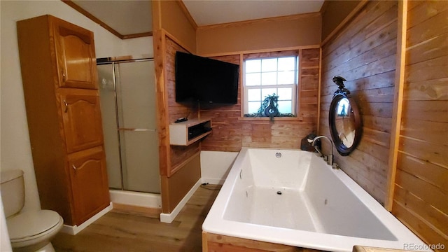 bathroom with hardwood / wood-style flooring, wood walls, toilet, and plus walk in shower