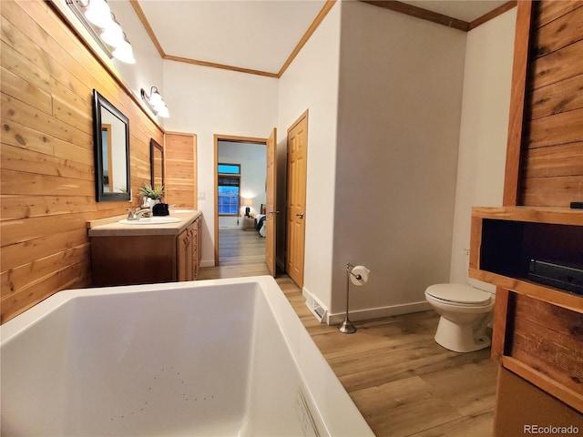 bathroom with a tub to relax in, crown molding, and wood walls