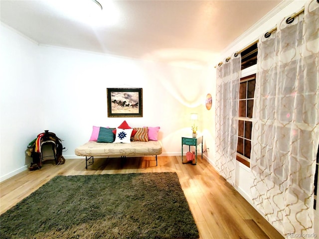 sitting room with light hardwood / wood-style floors and ornamental molding