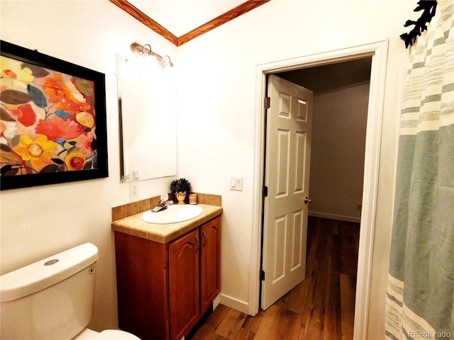 bathroom featuring hardwood / wood-style floors, vanity, toilet, and ornamental molding