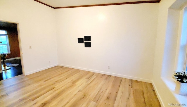 spare room with light hardwood / wood-style floors and crown molding