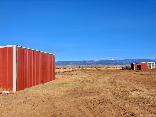 view of yard with a mountain view and a rural view