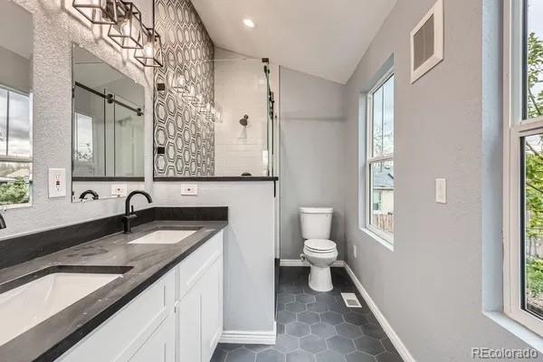 825 S Quitman St, Denver, CO 80219 - bathroom with vaulted ceiling, healthy amount of natural light, and tile patterned floors