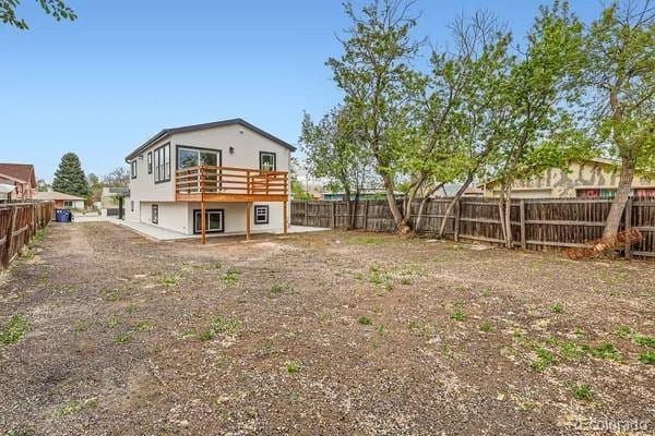 825 S Quitman St, Denver, CO 80219 - rear view of house with a fenced backyard and a wooden deck