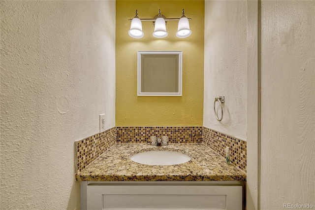 bathroom with vanity and tasteful backsplash