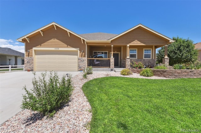 view of front of property with a garage, covered porch, and a front yard