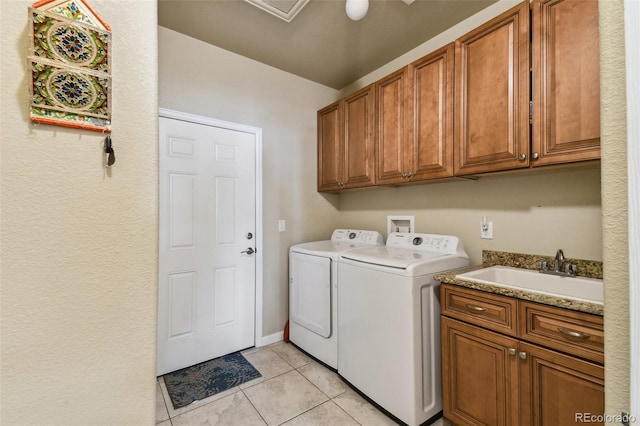 washroom with cabinets, sink, light tile patterned floors, and separate washer and dryer