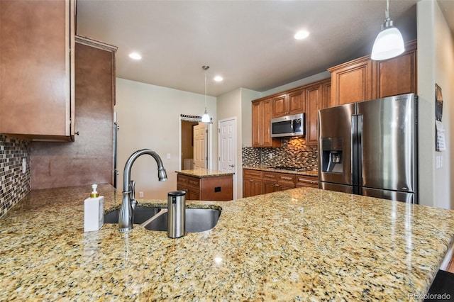 kitchen with appliances with stainless steel finishes, decorative backsplash, sink, kitchen peninsula, and light stone counters