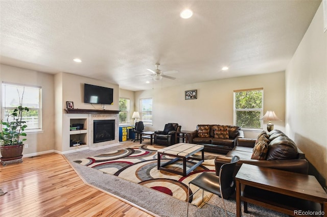 living room featuring light hardwood / wood-style floors, a wealth of natural light, and ceiling fan