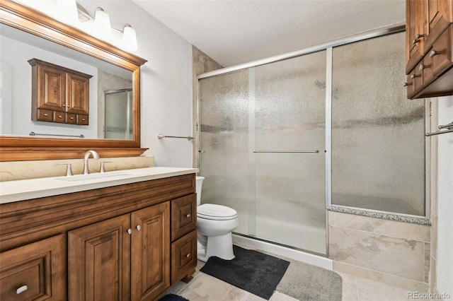 bathroom featuring vanity, toilet, walk in shower, and tile patterned flooring