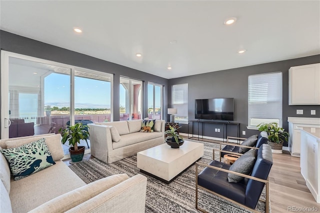 living area with light wood finished floors, recessed lighting, and baseboards