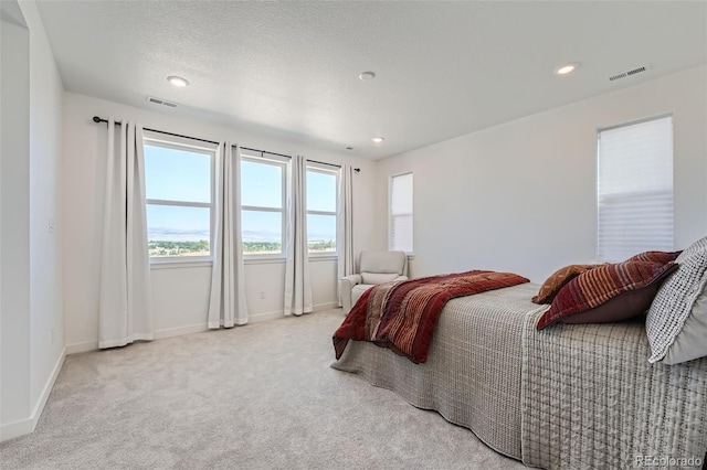 carpeted bedroom featuring recessed lighting, visible vents, and baseboards