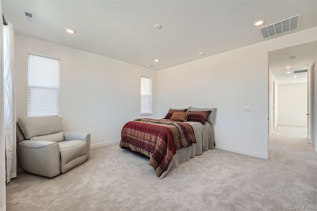 bedroom featuring recessed lighting, visible vents, light carpet, and baseboards