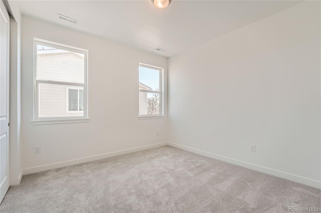 carpeted empty room featuring visible vents and baseboards