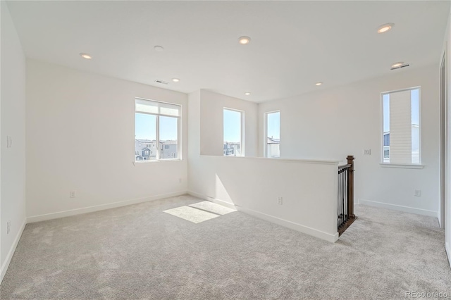 carpeted spare room featuring visible vents, recessed lighting, and baseboards