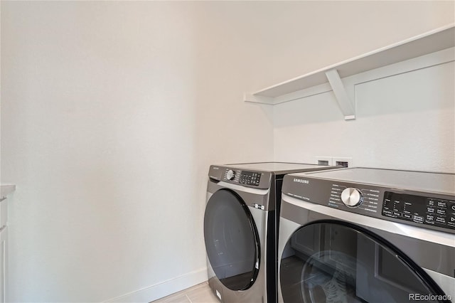 laundry room featuring baseboards, separate washer and dryer, and laundry area