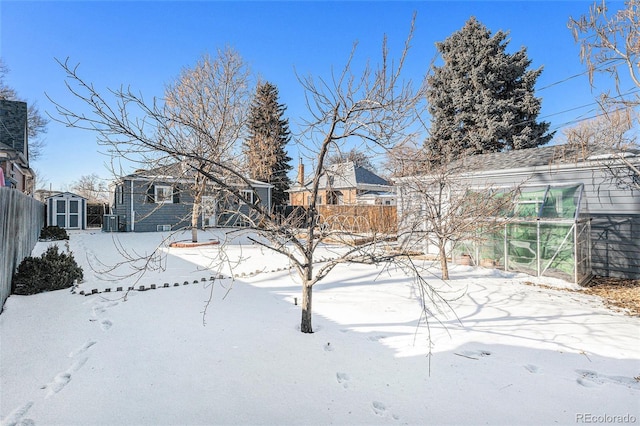 yard covered in snow featuring cooling unit and a shed