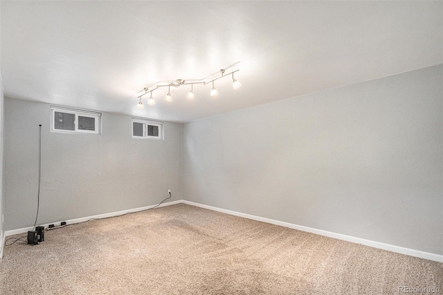 basement featuring track lighting and carpet