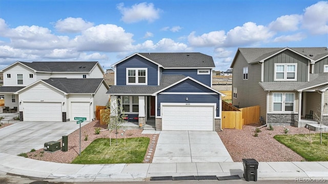 view of front facade featuring roof with shingles, fence, stone siding, a residential view, and concrete driveway
