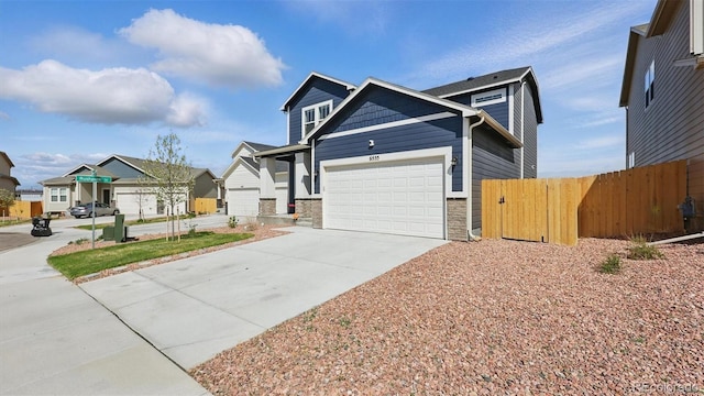 view of front facade with fence, stone siding, a residential view, driveway, and a garage