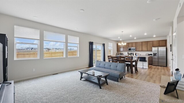 living area with an inviting chandelier, visible vents, baseboards, and recessed lighting