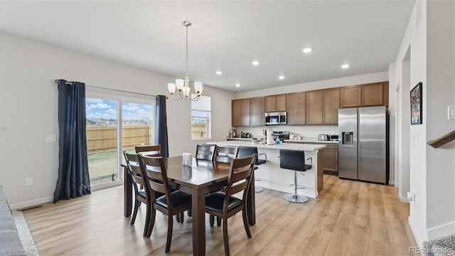 dining room with light wood finished floors, a chandelier, baseboards, and recessed lighting