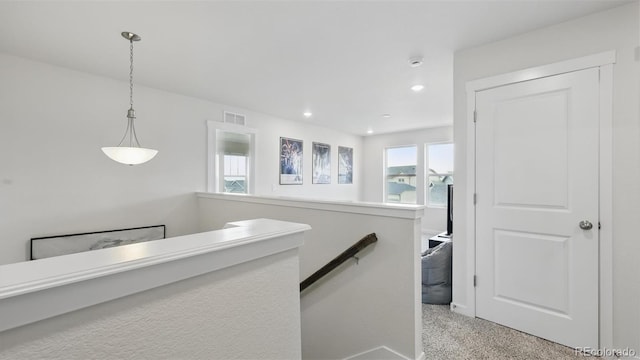 hallway with recessed lighting, an upstairs landing, visible vents, and light colored carpet