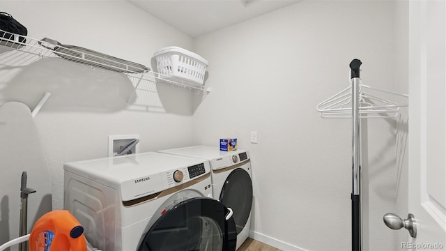 laundry room featuring laundry area, baseboards, separate washer and dryer, and light wood finished floors