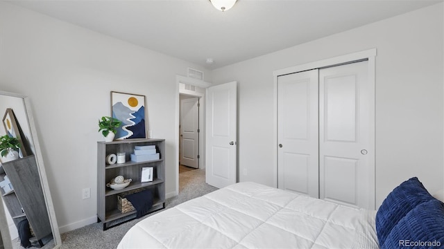 carpeted bedroom featuring baseboards, a closet, and visible vents