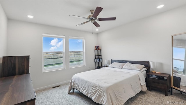 carpeted bedroom featuring multiple windows, visible vents, baseboards, and recessed lighting
