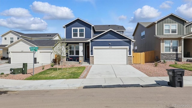 craftsman house featuring concrete driveway, board and batten siding, an attached garage, and fence
