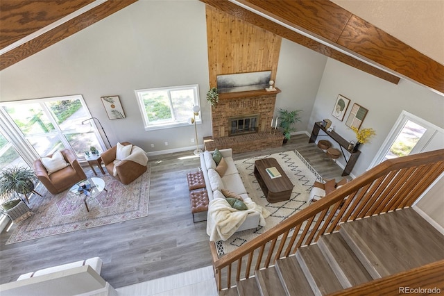 5195 Allison St, Arvada, CO 80002 - living area featuring high vaulted ceiling, a brick fireplace, wood finished floors, and beam ceiling