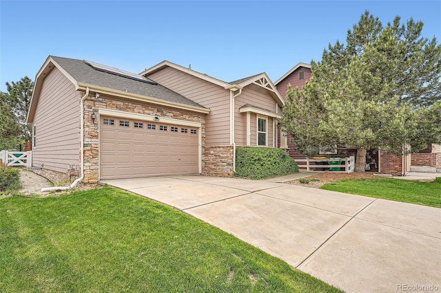 23882 E Alabama Dr, Aurora, CO 80018 - view of front facade featuring solar panels, a garage, driveway, and stone siding