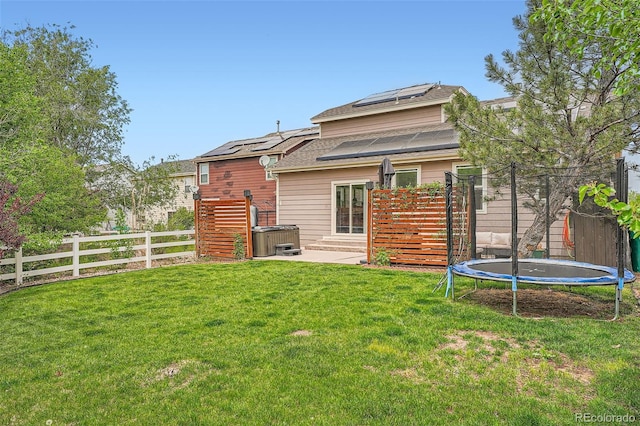 23882 E Alabama Dr, Aurora, CO 80018 - back of property featuring a trampoline, solar panels, a patio, and roof with shingles