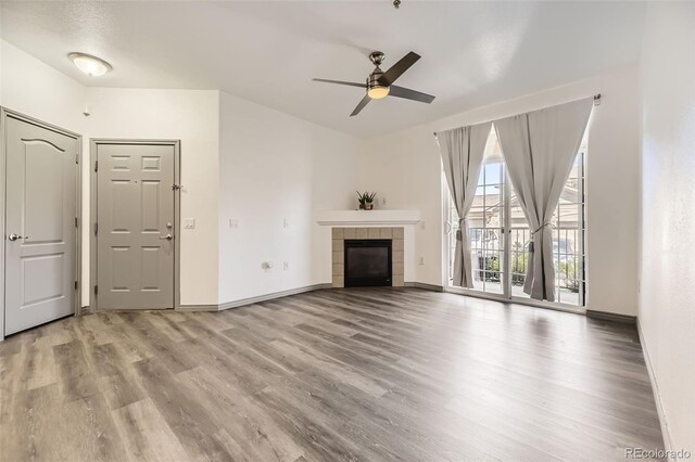 18657 Stroh Rd Unit 4103, Parker, CO 80134 - unfurnished living room with wood finished floors, ceiling fan, baseboards, and a fireplace