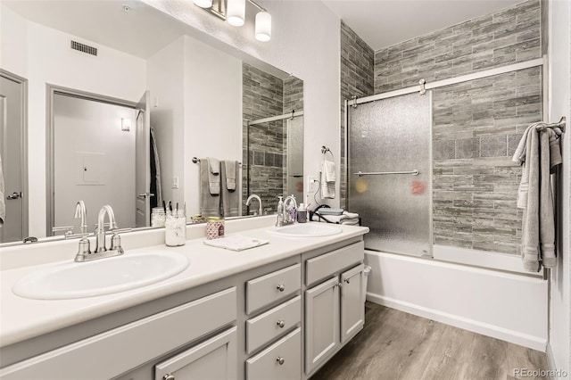 18657 Stroh Rd Unit 4103, Parker, CO 80134 - full bathroom featuring double vanity, bath / shower combo with glass door, and wood finished floors