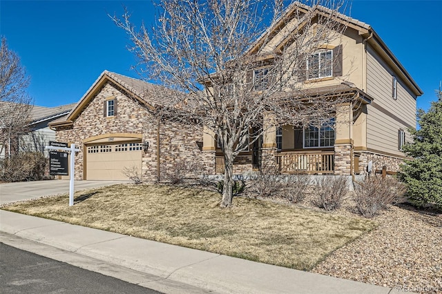 view of front facade featuring stone siding, concrete driveway, a tile roof, and stucco siding