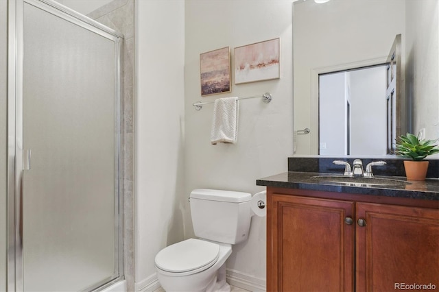 bathroom with vanity, toilet, and a shower with shower door