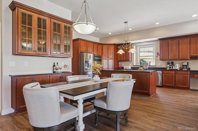 kitchen with hanging light fixtures, dark hardwood / wood-style floors, a center island, and appliances with stainless steel finishes