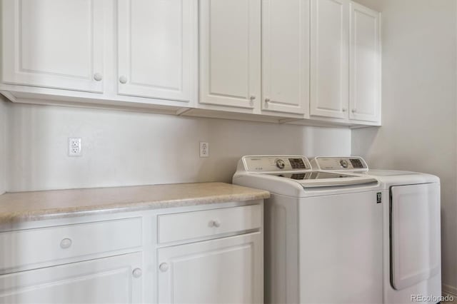 washroom featuring cabinets and washer and clothes dryer