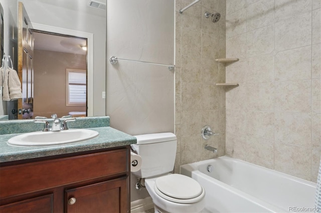 full bathroom with vanity, tiled shower / bath, and toilet