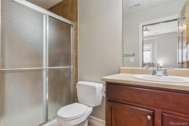 bathroom with vanity, toilet, and a shower with door