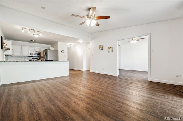 unfurnished living room featuring a ceiling fan, dark wood-style flooring, and baseboards